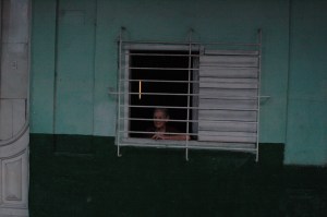 Kuba, sieviete aiz kioska loga